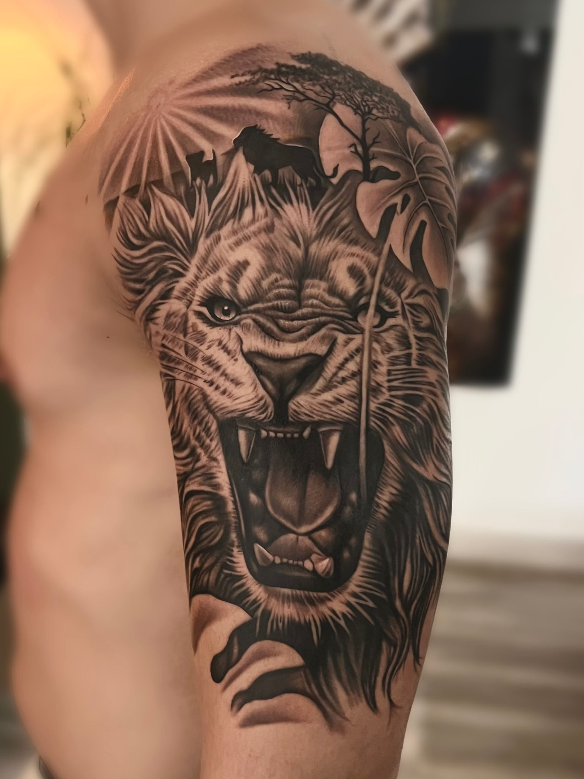 Een leeuw tattoo op de schouder