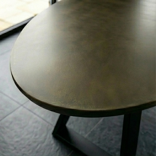 Detail van het bronzen tafelblad van de ovale eettafel Triad