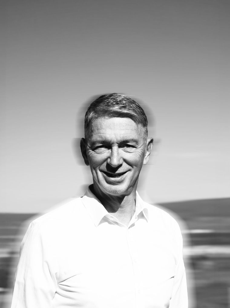 Portrait of Jörg Hefer against a black-and-white, motion-blurred landscape around Ingelheim.