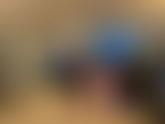 Two people practising martial arts indoors. One wears a blue shirt, the other a turquoise top. Bookshelves and a window view in the background.