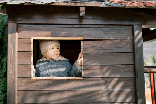 little-girl-looks-out-of-the-window-of-a-toy-woode-2026-03-17-07-15-29-utc.jpg