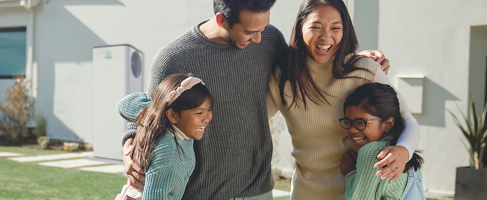happy family of four in front of a Emerald unit installed at their home