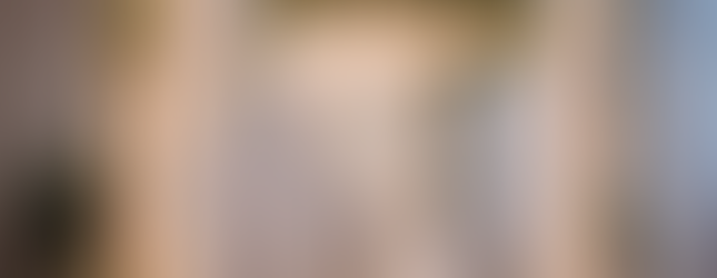 A classic birch wood chuppah decorated with fairy lights, fabric drapes, and greenery