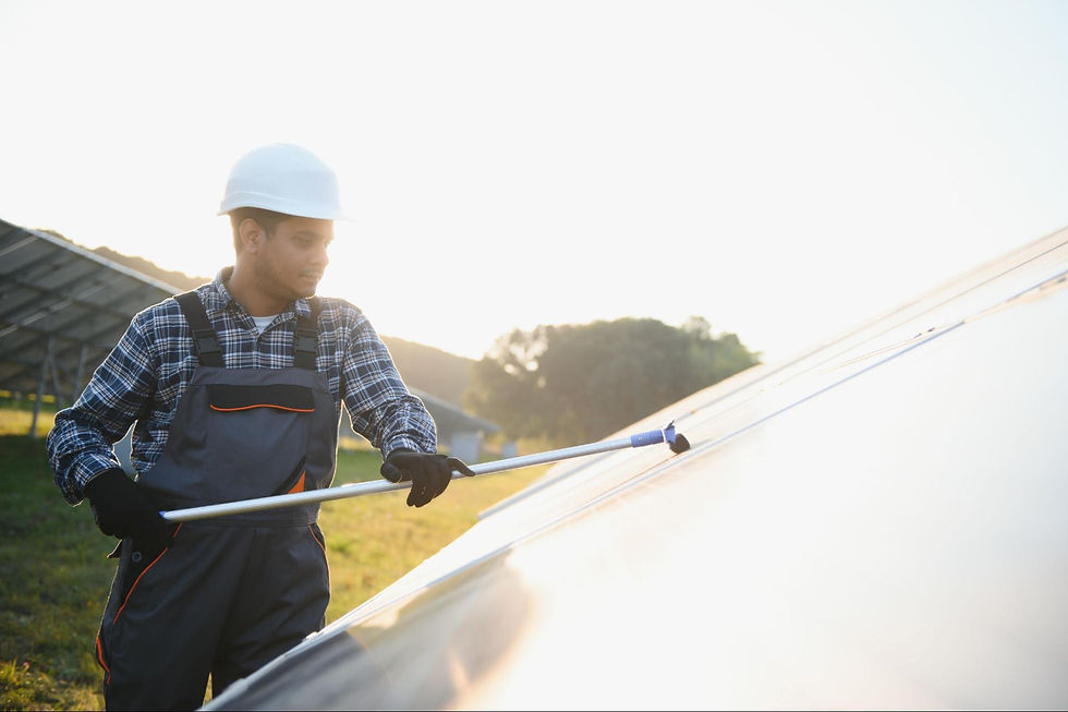 Worker performing solar panel maintenance by cleaning panels in a green field