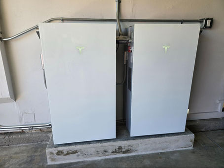 Close-up of two home solar battery systems installed on a garage wall