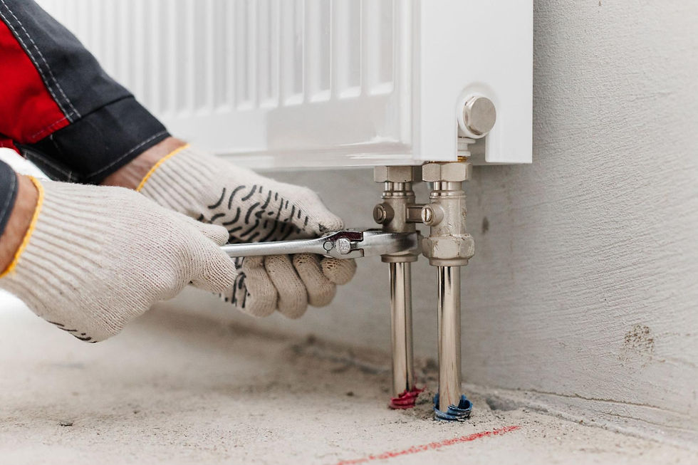 HVAC technician adjusting a heating pipe with a wrench during heating system repair