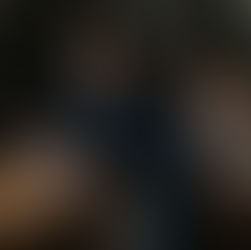 A man who cheated on his wife sits contemplatively on a leather chair, holding a cup, surrounded by bookshelves, absorbed in thought amidst personal turmoil.