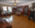 This spacious front room preserves the home's character with original millwork, a fireplace, and flexible seating for conversation, quiet visits, and family time.