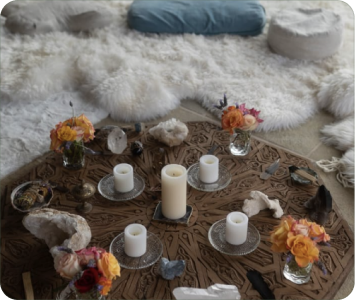 A carved wooden altar with candles, crystals and flowers on soft sheepskin