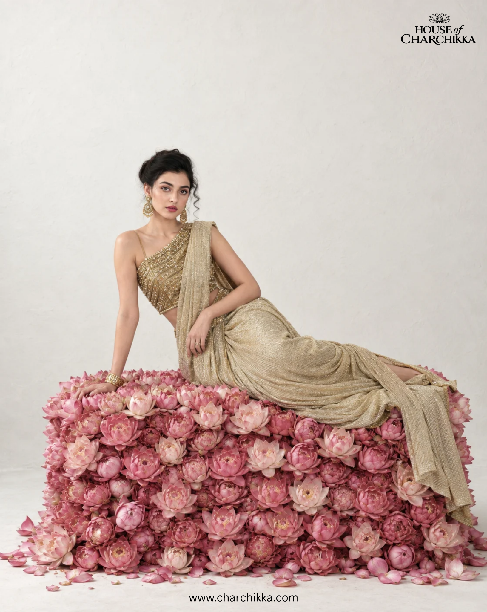 Designer Sarees collection: model wearing a gold saree on a bed of pink lotus flowers