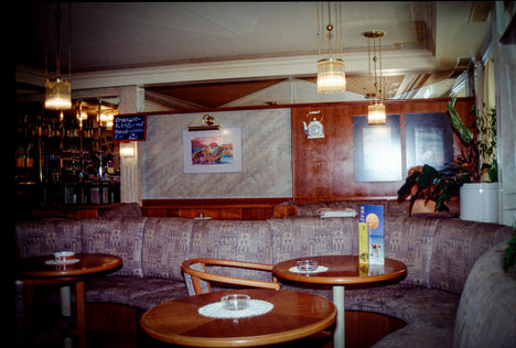 Historischer Gastraum des Café Piccolo mit Bar und runden Tischen