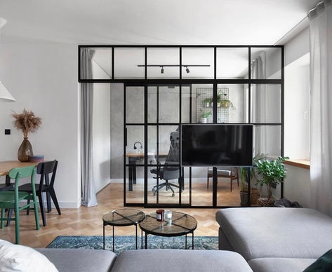 Glaswand mit Schiebetür zwischen Wohnzimmer und Büro