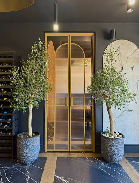 Loft-Tür für ein italienisches Restaurant in Berlin aus geschweißtem Stahlprofil in RAL1036 PerlGold mit kombiniertem geriffeltem und transparentem Glas, Griffen Modell New York und magnetischem Schließsystem