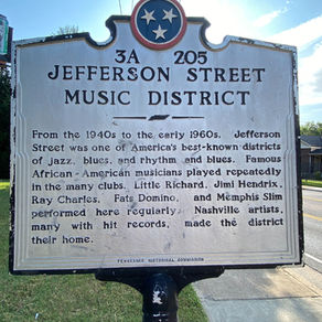 Historical marker for Jefferson Street Music District, noting its significance for jazz, blues, and iconic musicians, under a clear sky.