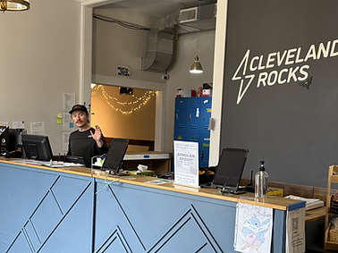 Front desk and welcome area of Cleveland Rocks Climbing with staff assisting visitors.