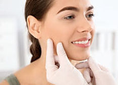 Dermatologist examining patient's face in clinic_ Skin cancer checkup.jpg