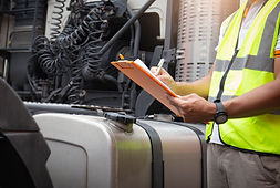 truck-driver-holding-clipboard-checking-safety-large-fuel-tank-semi-truck (1).jpg