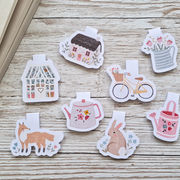 Cottage-shaped magnetic bookmarks with countryside illustrations.