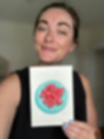 woman smiling holding a painting of raspberries