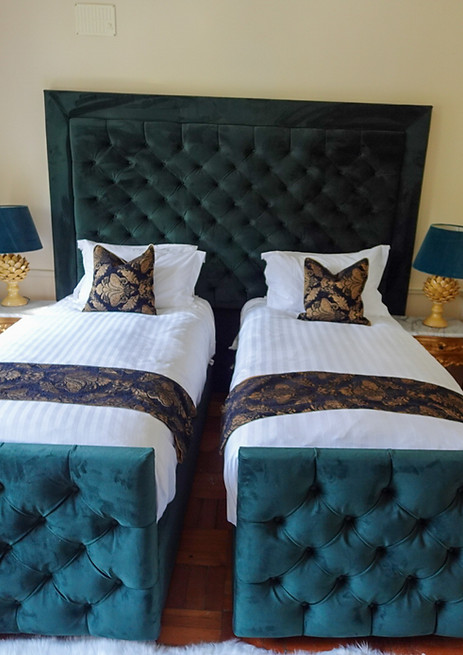 Elegant twin bedrooms with green upholstered beds