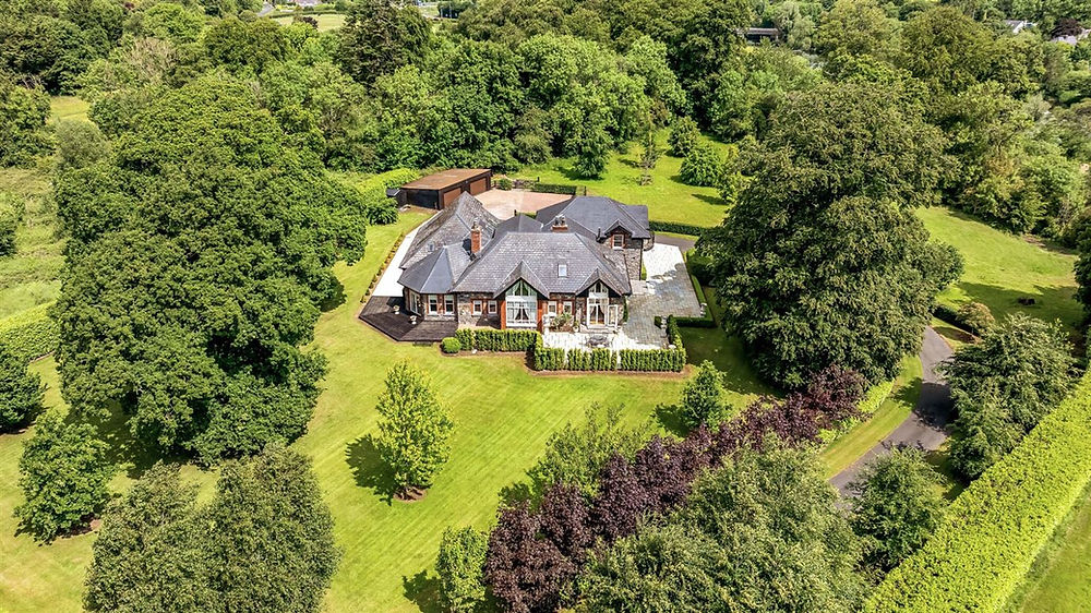 Aerial view of a large house with extensive green grounds