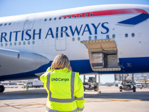 Woman in IAG Cargo jacket loading cargo into British Airways plane