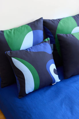 Ambiance déco chaleureuse dans une maison à Paris, coussins et couleurs douces.