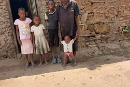 A family outside their mud-brick home — rural Kilifi, 2024.webp