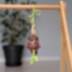 Crocheted hanging toy with a beaver rattle in brown-green palette