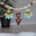 Crochet stroller chain with soft beaver and wooden ring, botanical motifs in brown-green colors