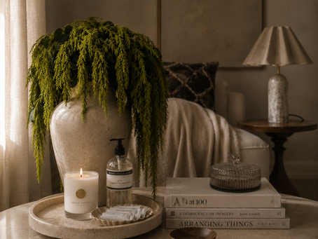 Quiet luxury interieur met beige plaid, luxe kaars, handzeep en keramieken vaas in warme hotel aesthetic woonkamer