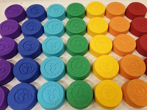 Bath bombs in a rainbow of colours, each colour displaying a different chakra symbol