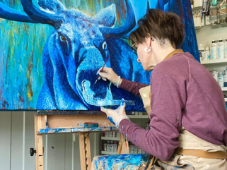 Michele Doucette painting a blue moose