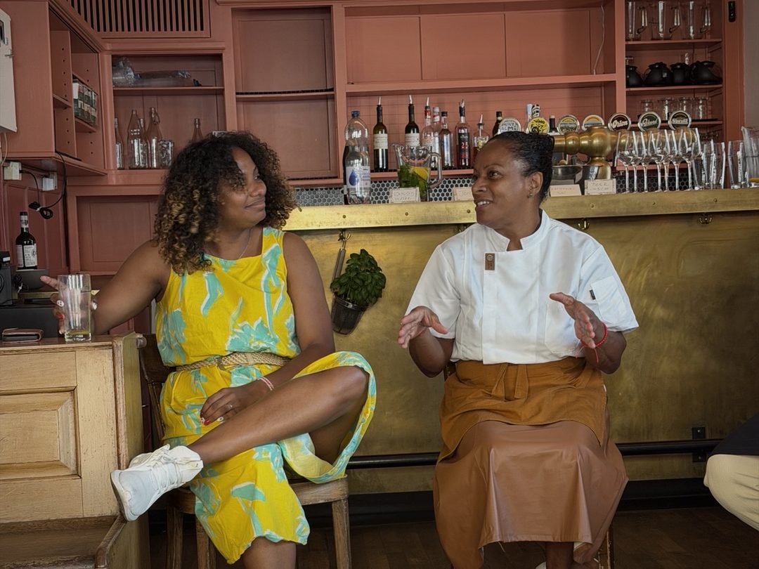 The chef talking with her hands, a woman in yellow listening