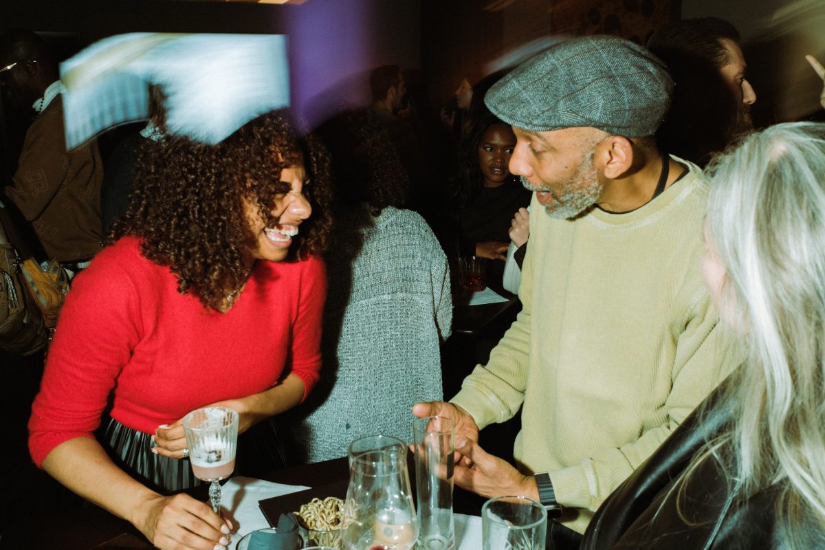 A guest laughing with a man in a flat cap