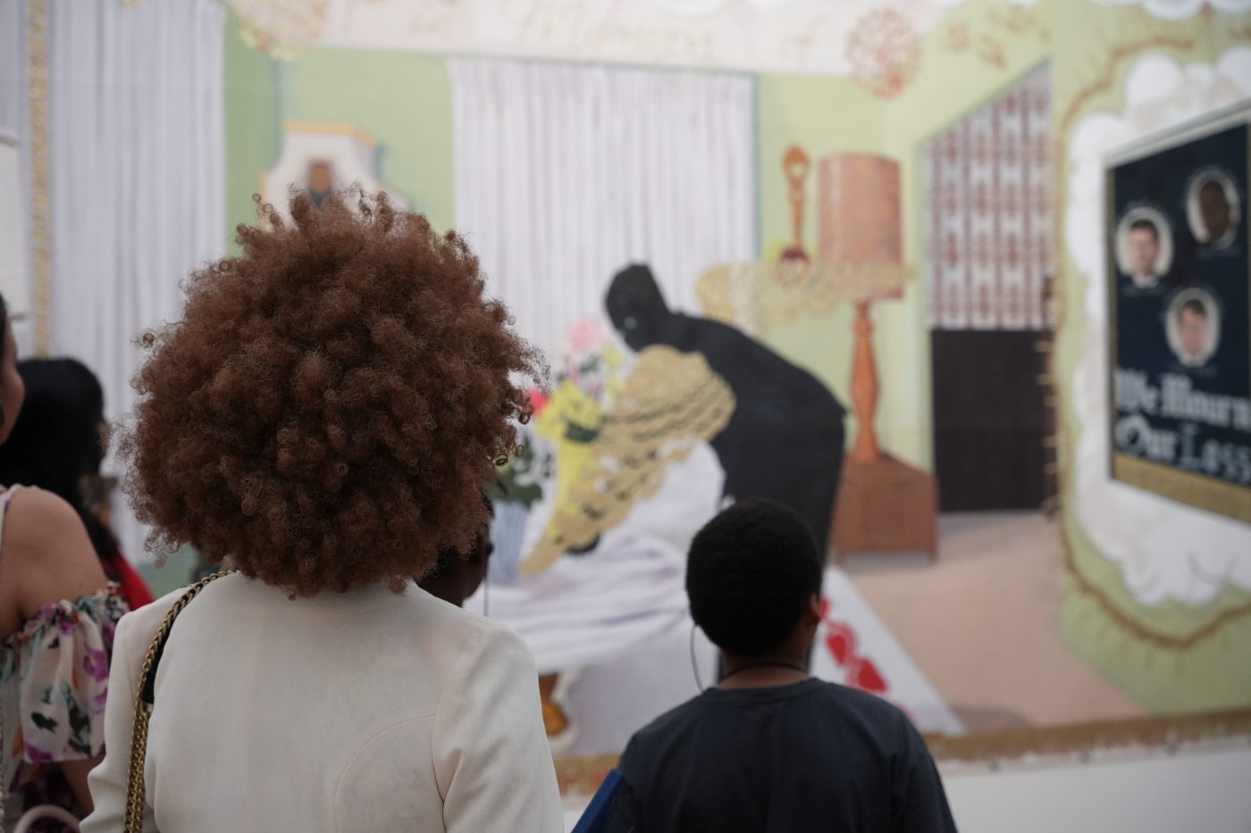 A guest and a child in front of a large painting