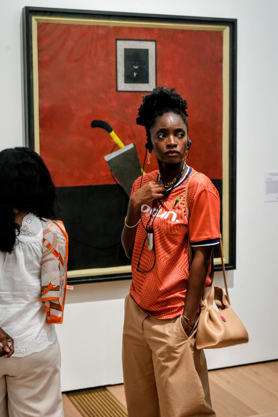 A guest with an audio guide in front of a red painting