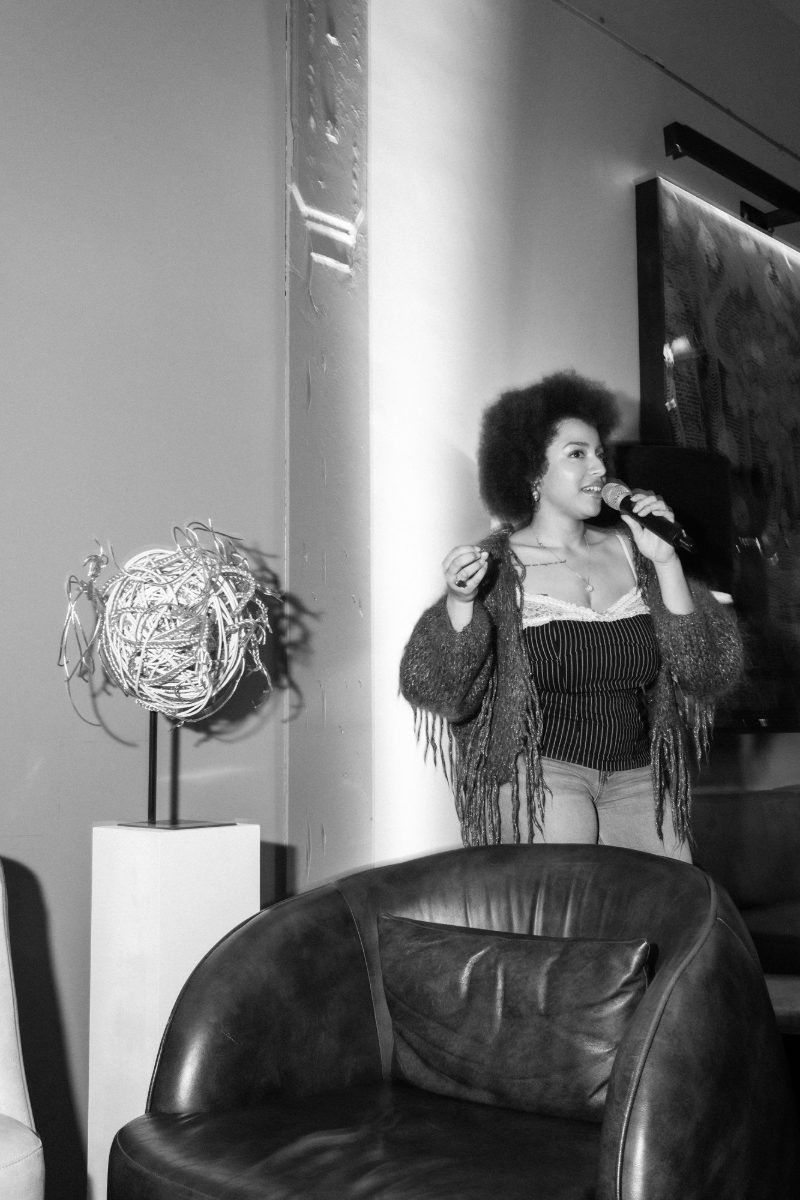 Christin Khaukha with a microphone, in black and white