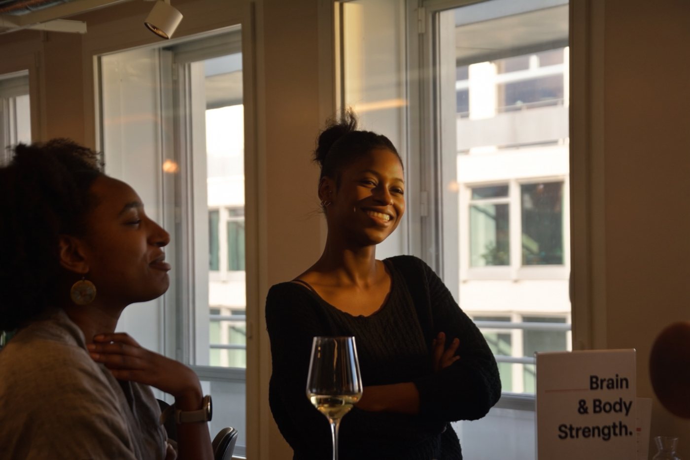 Two guests by a window, one holding a glass of wine
