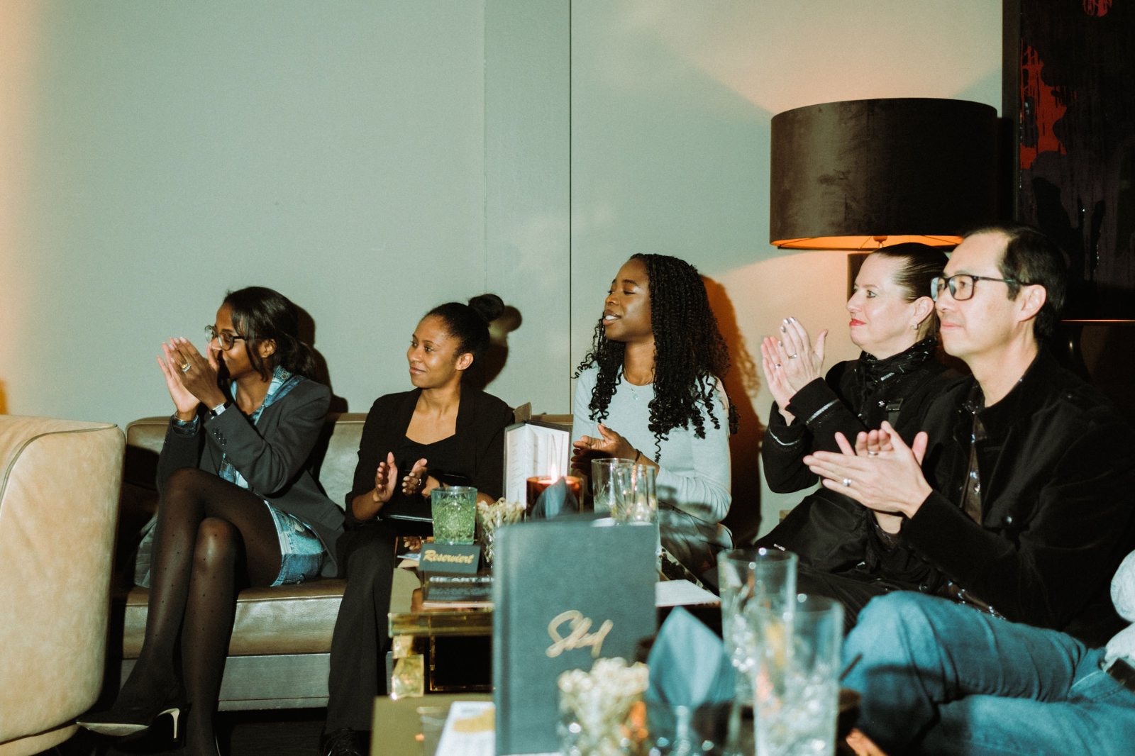 Guests on a sofa applauding during the evening