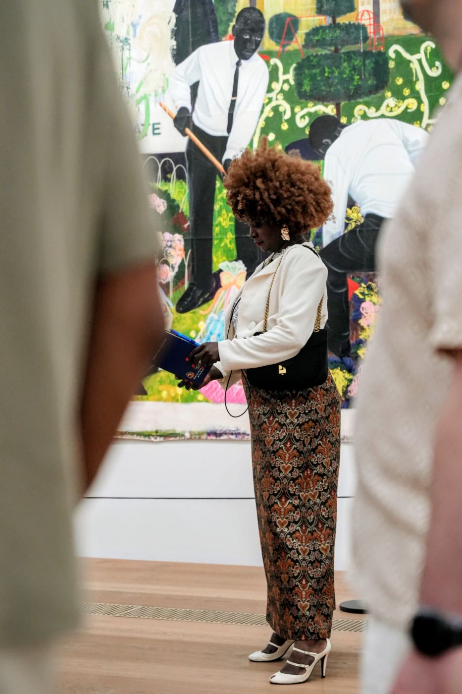 A guest reading her notes in front of a painting