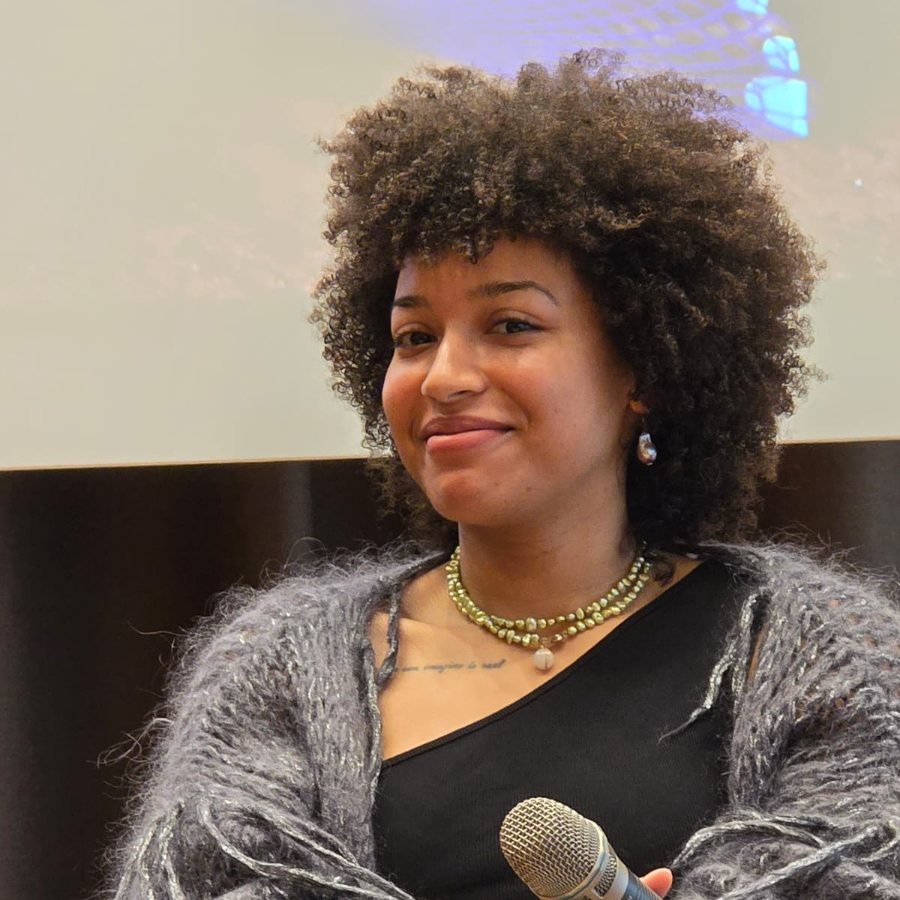 Christin Khaukha with a microphone, smiling