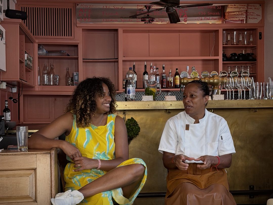 Two women smiling at each other in conversation at the bar