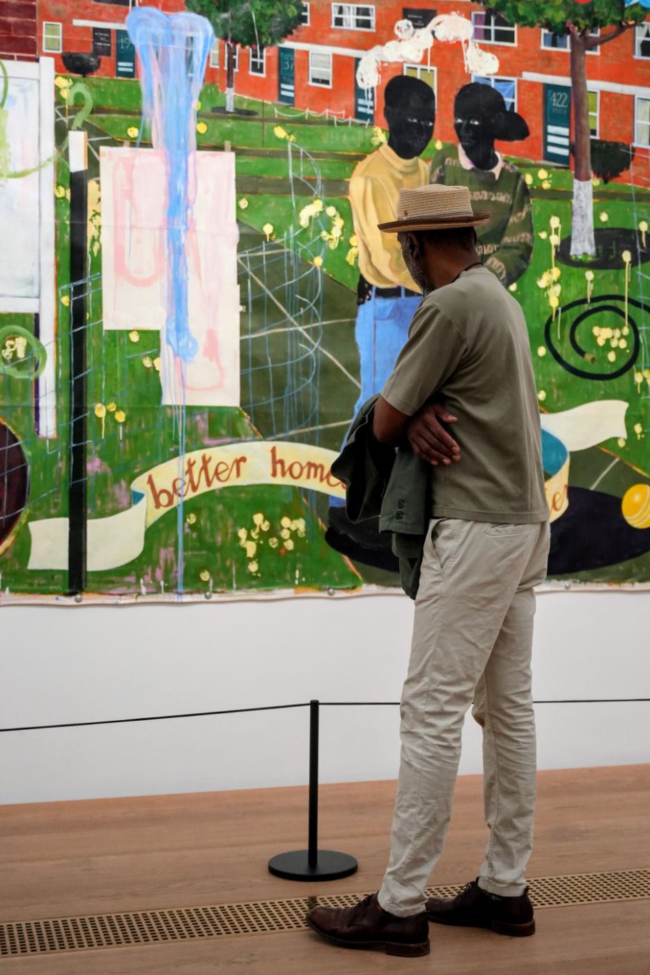 A guest in a straw hat looking at a painting