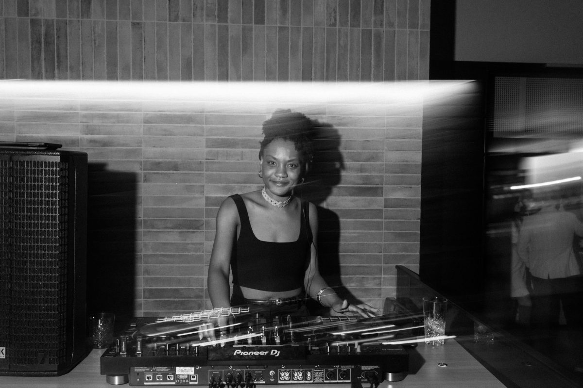 The DJ smiling at the decks, in black and white