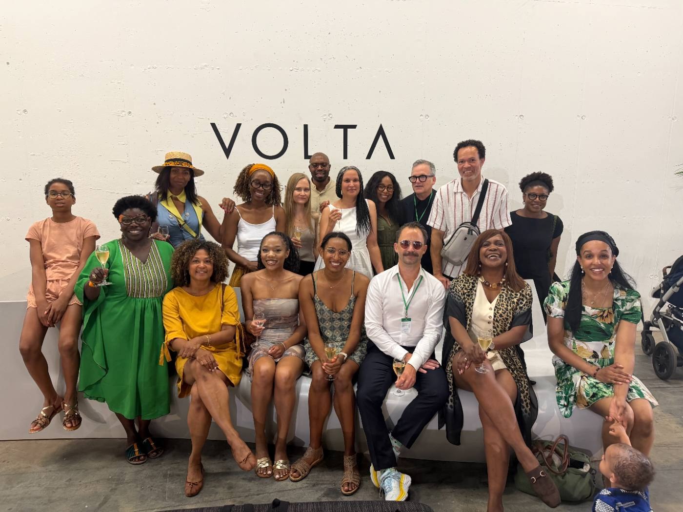 The REMAIN group at VOLTA, seated and standing in front of the VOLTA lettering