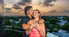 A man and woman are hugging at the top of the Key West Lighthouse overlooking Duval Street and the southernmost point during sunset