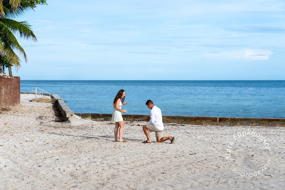 A man is down on one knee for a Key West beach proposal to his girlfriend