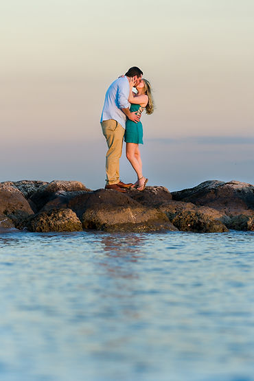 A man and woman share a kiss after getting engaged during sunset in Key West