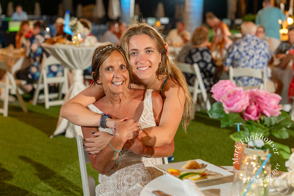A Key West bride being hugged by her maid of honor during their Key West wedding reception